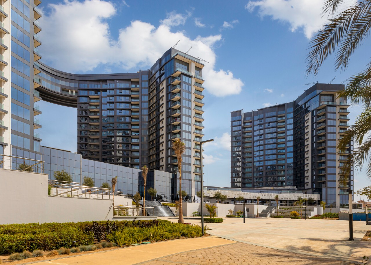 Nestled in a prime location within the vibrant city of 6th of October, near the expansive central park of Sheikh Zayed, Zed Sheikh Zayed Compound enjoys a truly strategic setting. Its advantageous position offers residents stunning panoramic views, while keeping essential amenities within close reach.
The towers incorporate high-performance solar control glazing from Guardian Glass, specifically the Guardian SunGuard™ HP Neutral Plus 50 and Guardian SunGuard™ Neutral 40. These solutions successfully bring the architectural vision to life.
From an aesthetic perspective, the towers feature sleek, modern glass façades that reflect the elegance of contemporary skyscrapers. The use of neutral grey glass aligns seamlessly with the overall design palette, complementing the grey cladding and reinforcing the project’s luxurious, high-end character.